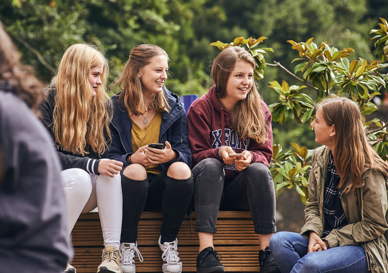 Semi intensive English course students sitting outside the English school in Jersey, UK